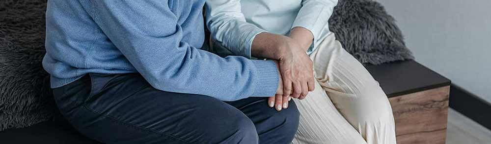Pareja se cogen las manos. Se dan apoyo ante los síntomas de los últimos días de vida